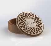 circular jewelry organizer with a diamond pattern engraved with the word love on the lid